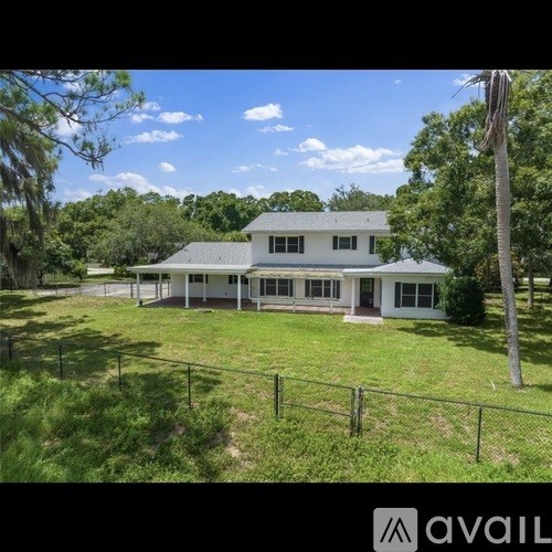 A white house with a black fence in front of it.