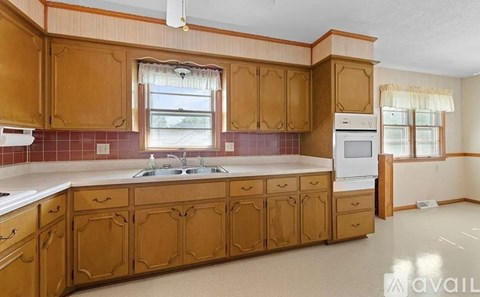 A kitchen with wooden cabinets and a white countertop.