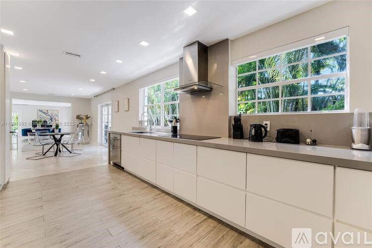 A modern kitchen with white cabinets and a large island.