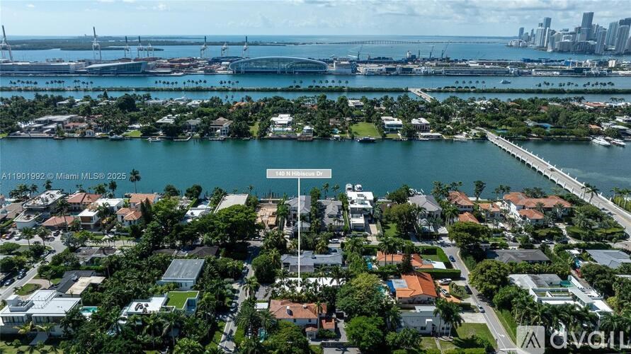 A bird's eye view of a residential area with a bridge in the background.