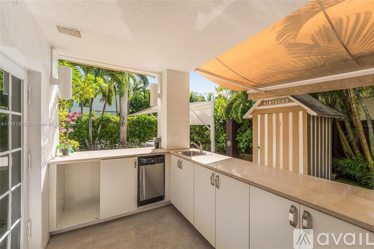 A kitchen with white cabinets and a view of the outdoors.