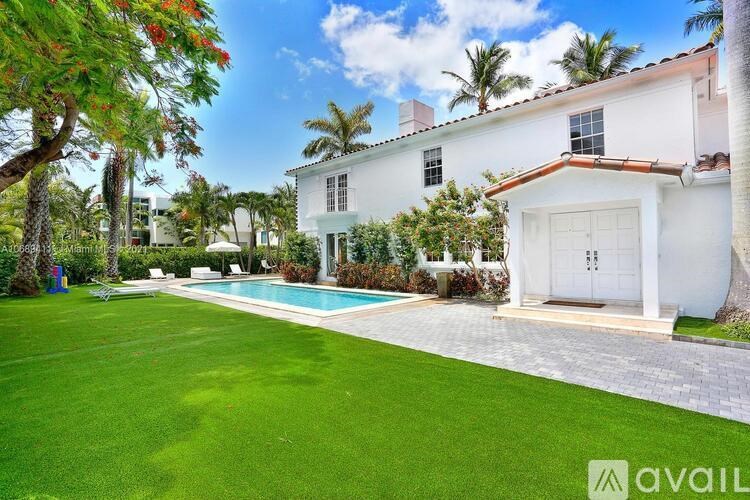 A white house with a pool in the backyard.