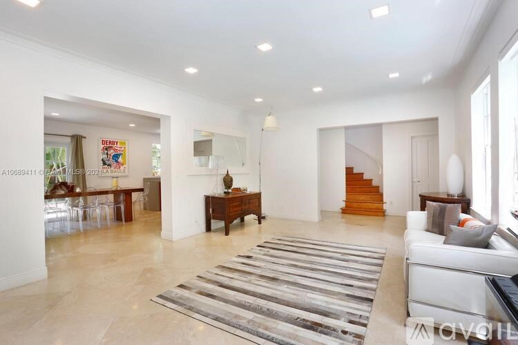 A spacious living room with a striped rug on the floor.