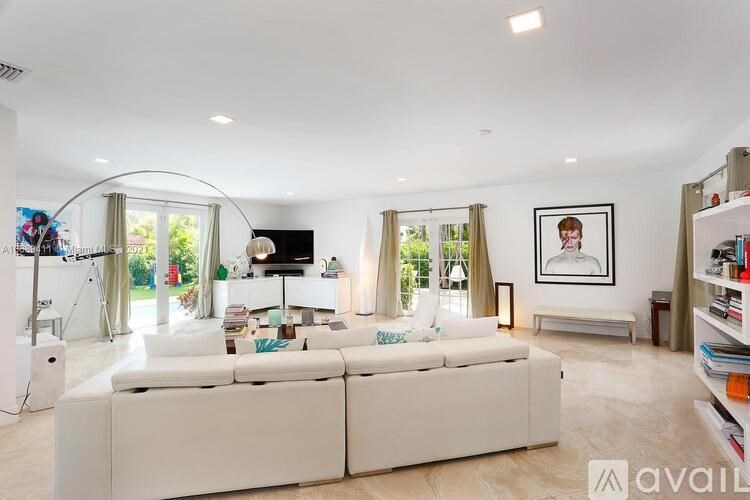 A living room with a white couch and a television.