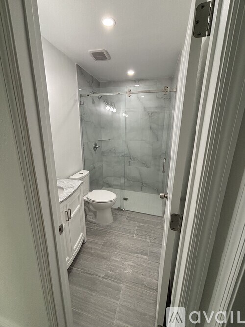 A bathroom with a toilet, sink, and walk-in shower.