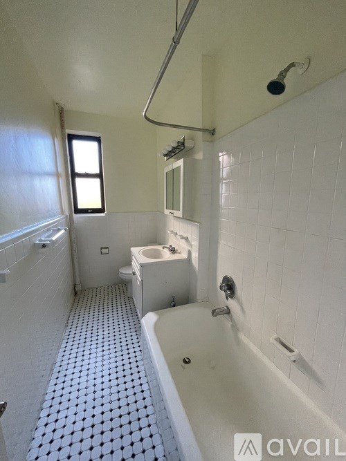 A bathroom with a white tub and tiled floor.