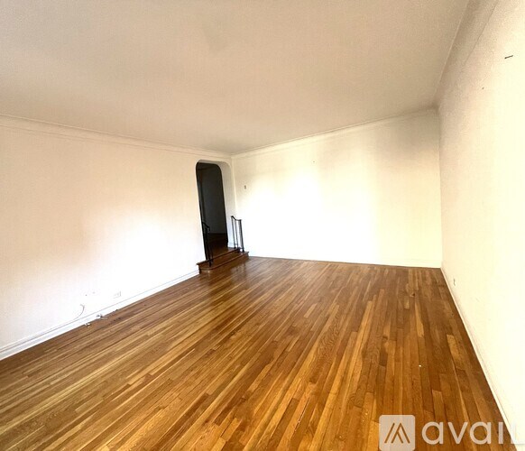 A room with wooden flooring and a black object on the floor.