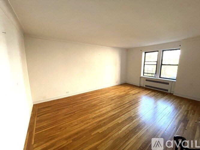 A room with wooden flooring and a window.