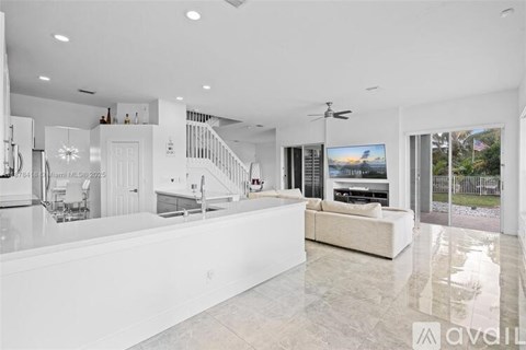 A spacious living room with a large white sofa and a television.