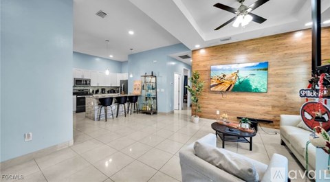 A living room with a kitchen area in the background.