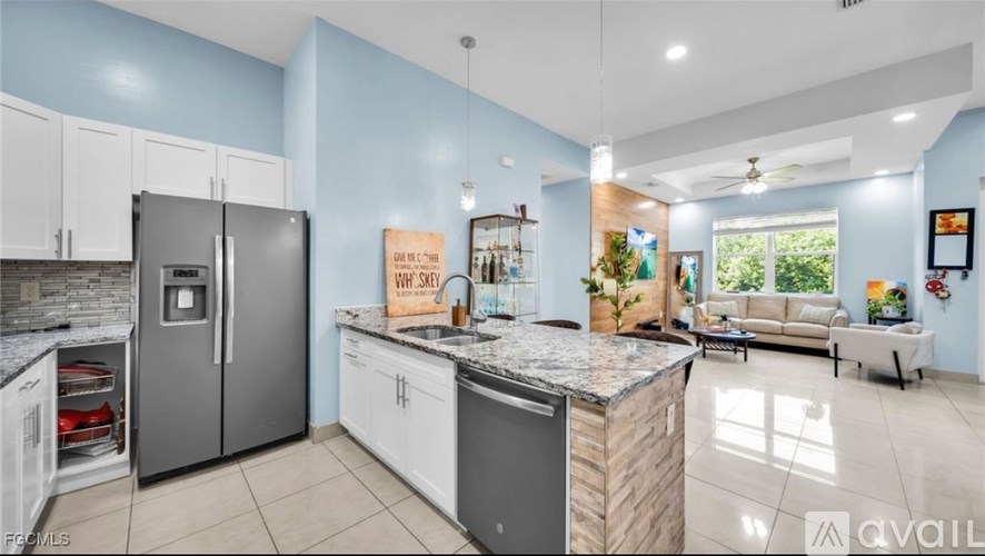 A kitchen with a refrigerator, cabinets, and a countertop.