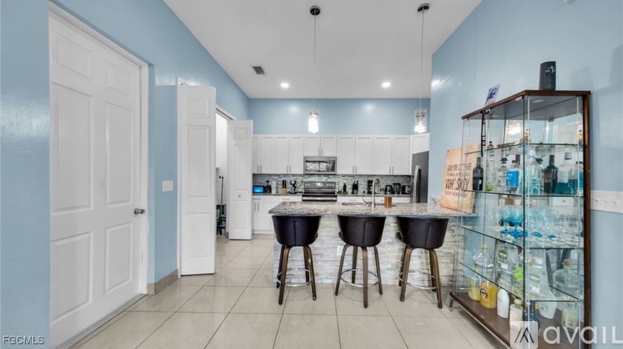 A kitchen with a blue wall and white cabinets.