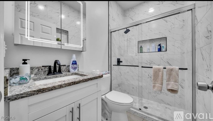 A bathroom with a marble wall and a toilet.