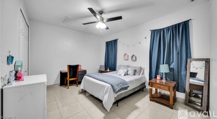 A bedroom with a bed, nightstand, and chair.