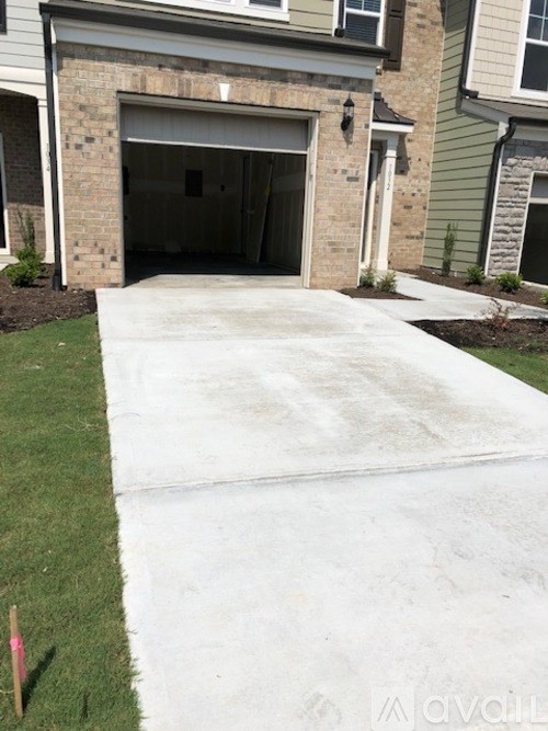 A garage door is open and the garage is empty.