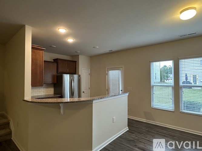 A kitchen with a granite countertop and a refrigerator.
