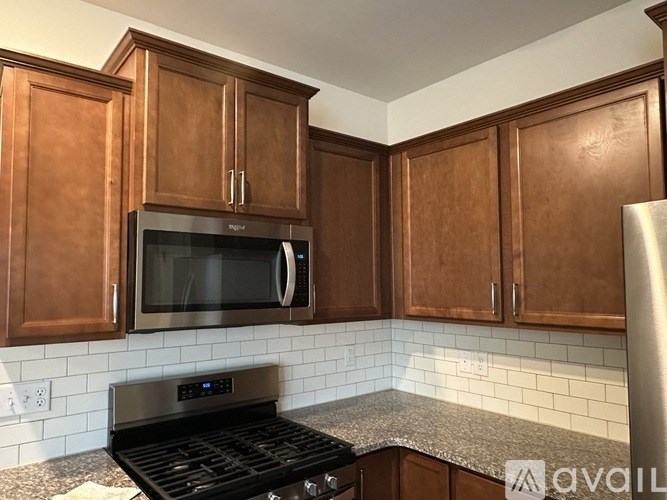 A kitchen with brown cabinets and a black stove top oven.