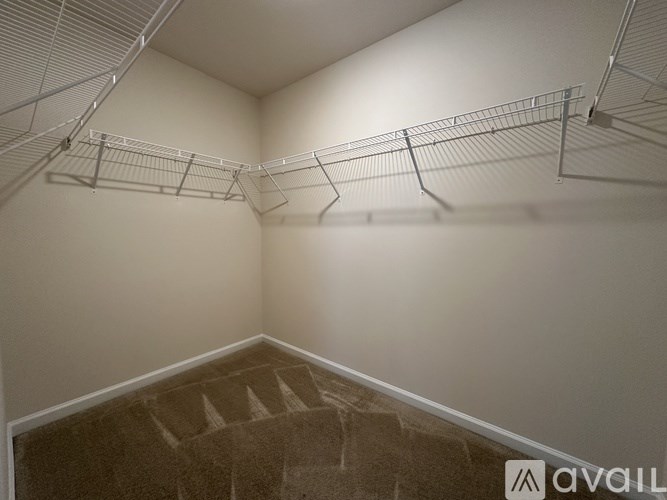 Empty room with a staircase and metal shelves.