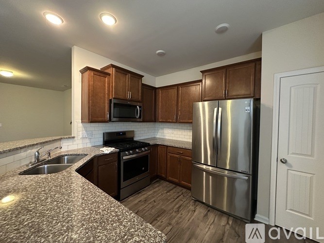 A kitchen with a stainless steel refrigerator, microwave, and oven.