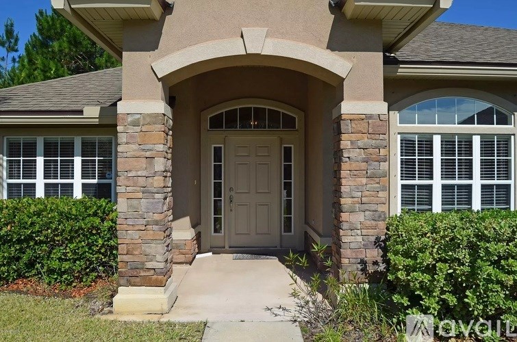 A house with a grey front door and stone pillars.