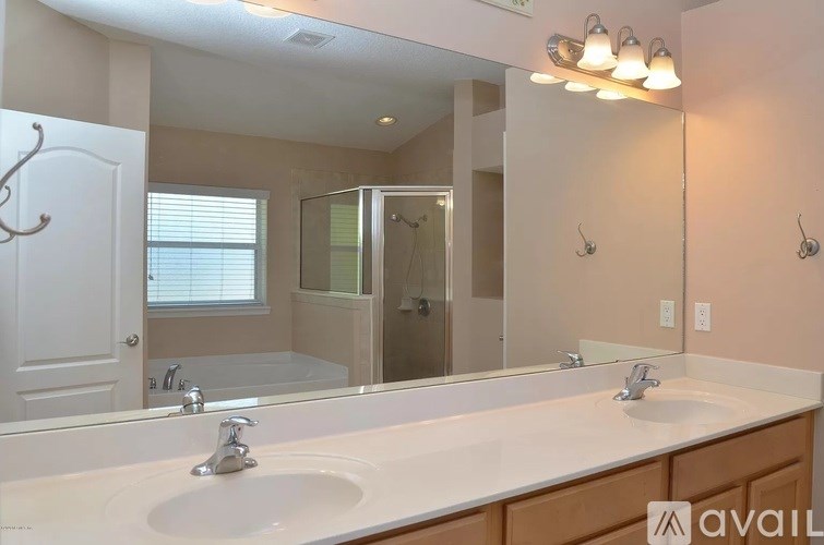 A bathroom with two sinks and a large mirror.