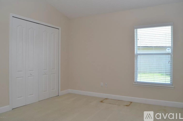 A room with a white door and a window with blinds.