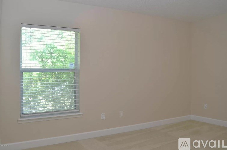 A room with a window and a wall socket.