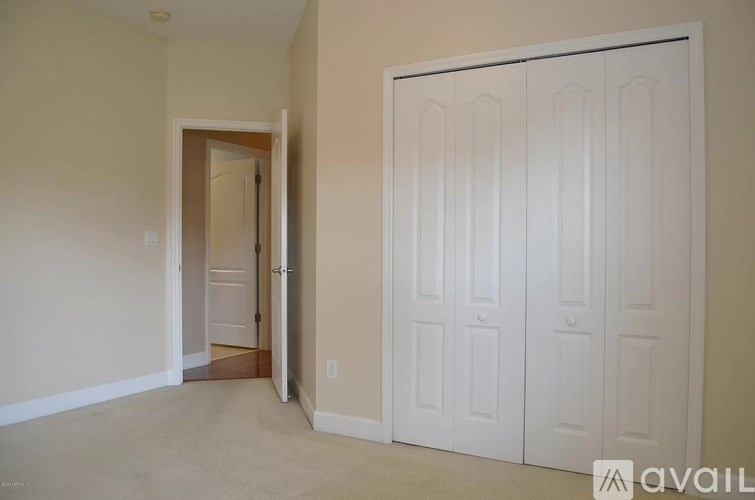 A room with a white door and a white wardrobe.