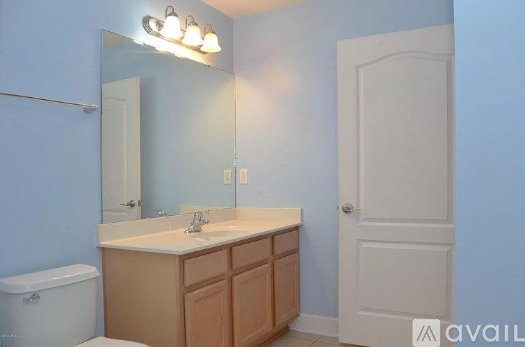 A bathroom with a sink, mirror, and toilet.