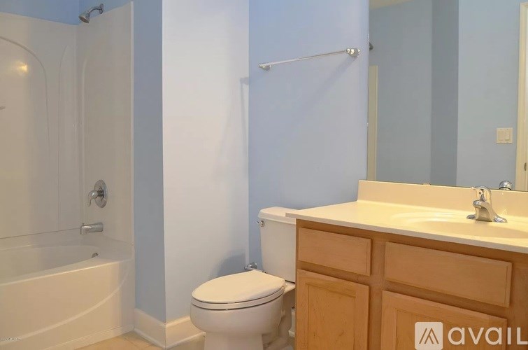 A bathroom with a toilet, sink, and bathtub.