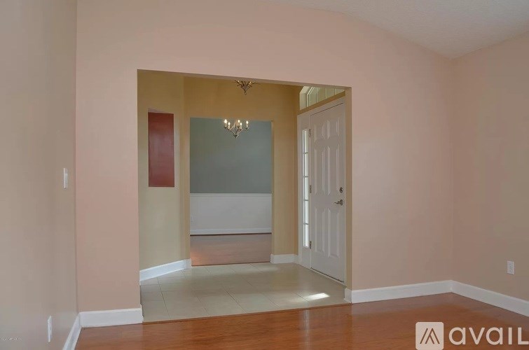 A room with a chandelier and a door.