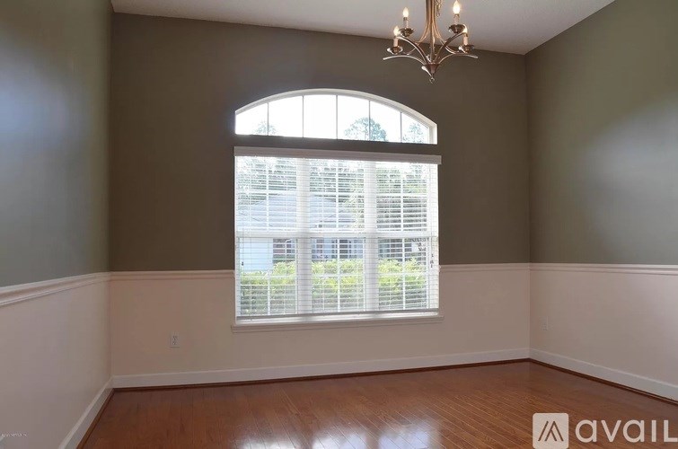 A room with a large window and a chandelier.