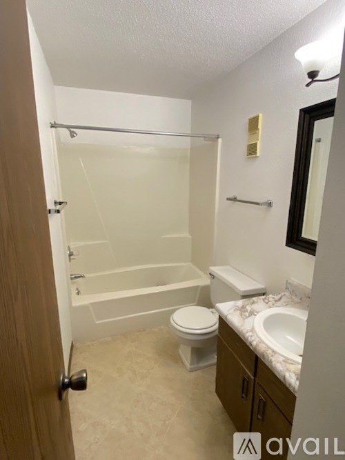 A bathroom with a toilet, sink, and bathtub.