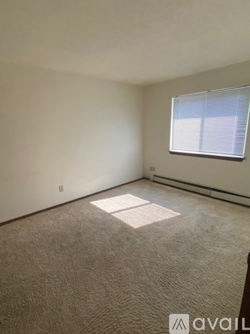 A room with a window and carpeted floor.