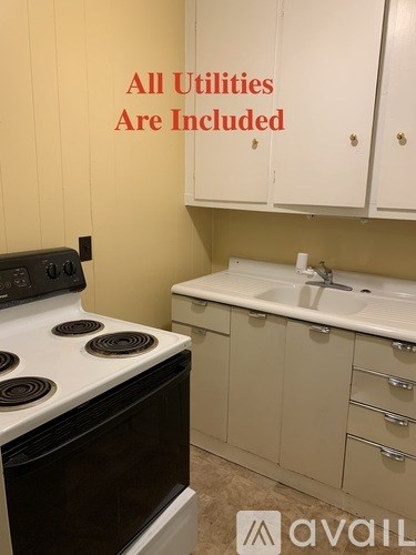 A kitchen with a stove top oven and a sink.