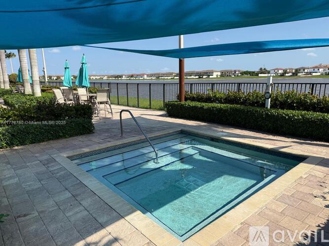 A pool with a slide and a blue umbrella.