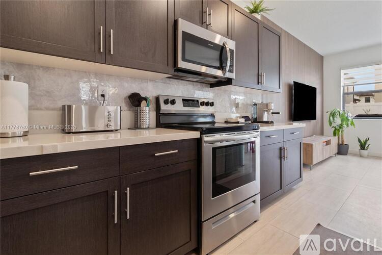 A kitchen with dark wood cabinets and stainless steel appliances.