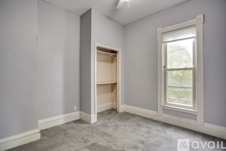 A room with a window and a doorway leading to another room.