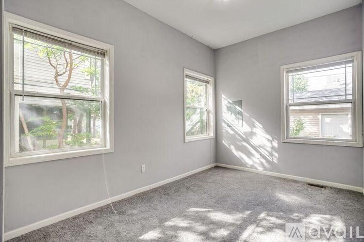 A room with two windows and a carpeted floor.