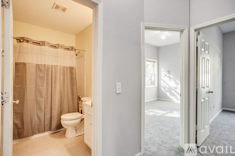 A bathroom with a toilet and a shower with a curtain.