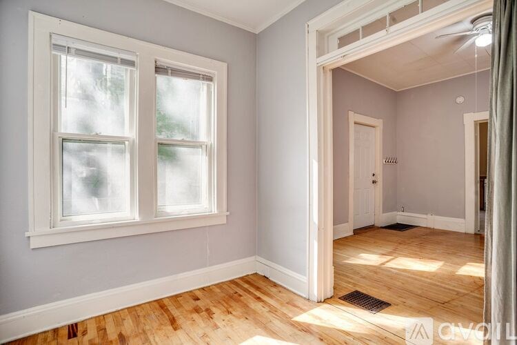 A room with a window and wooden floors.