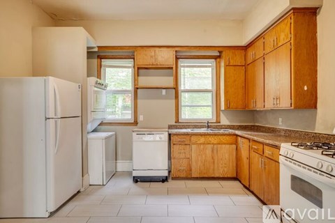 A kitchen with wooden cabinets and a white refrigerator.