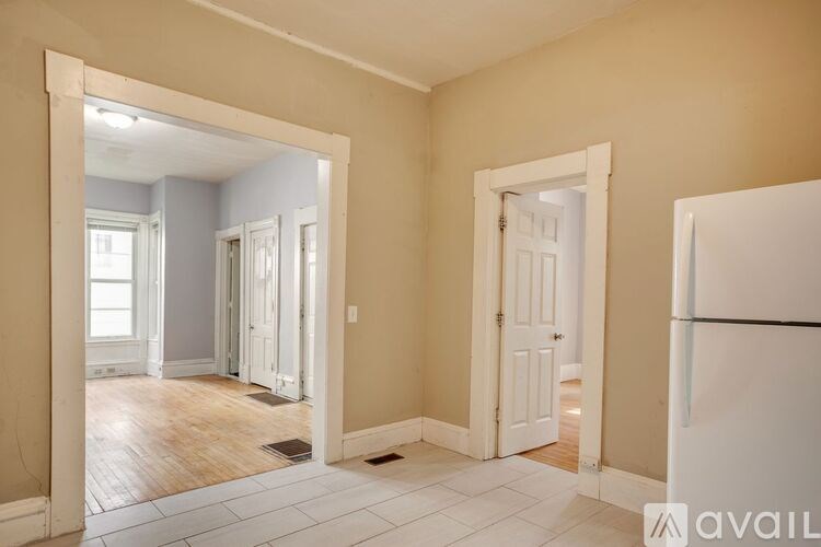 A room with a white fridge and a white door.