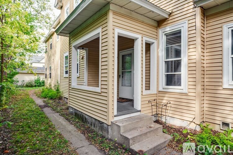 A beige house with a white door and windows.