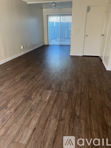 A room with wooden flooring and a white door.