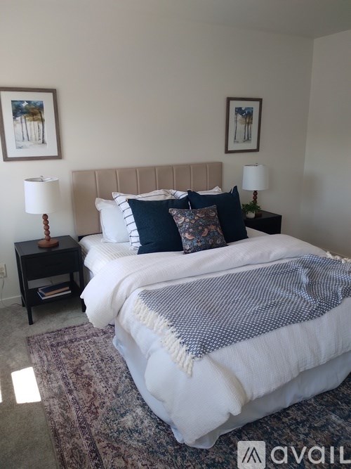 A bedroom with a large bed and two nightstands.