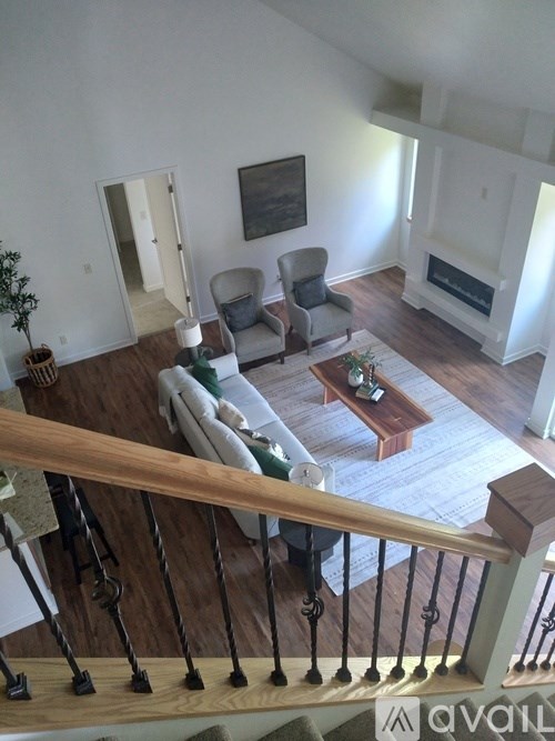 A living room with a couch, chair, and a painting on the wall.