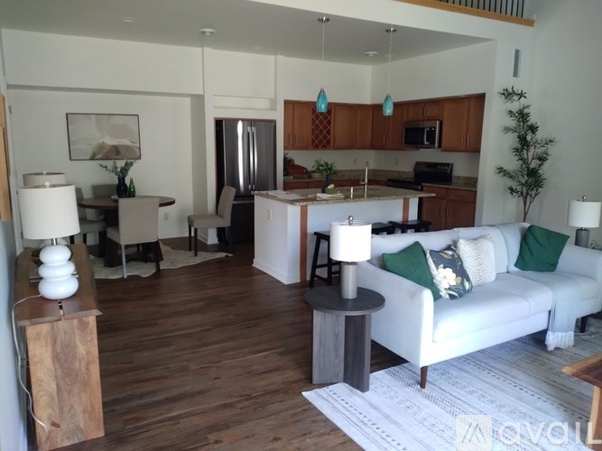 A living room with a white couch and a wooden floor.