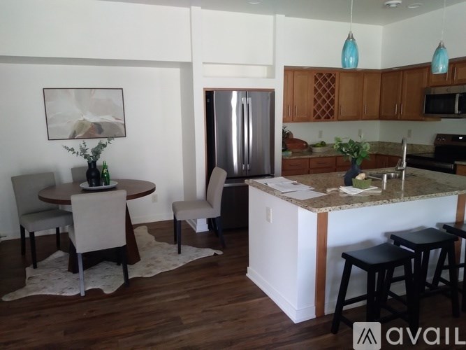 A kitchen with a table and chairs in the foreground and a refrigerator in the background.