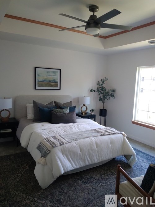A bedroom with a large bed and a ceiling fan.